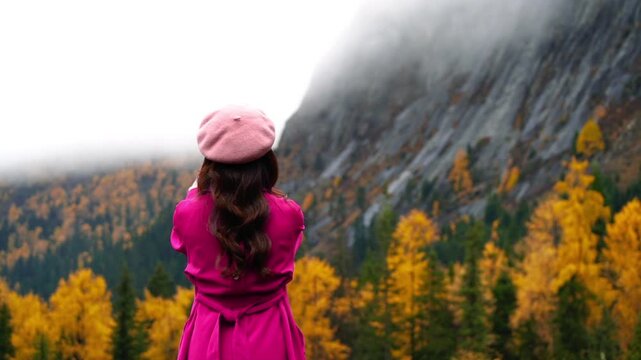 Tourists are taking photos at Siguniangshan in autumn, Sichuan in China.