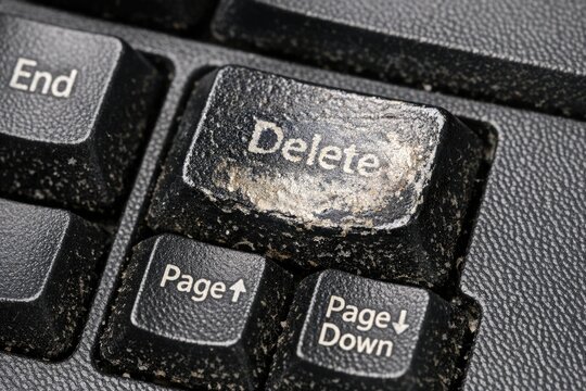 A close-up view of a computer keyboard with the 'delete' button highlighted