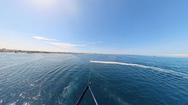 First person view of a parasailing flight over the deep blue sea on a sunny day