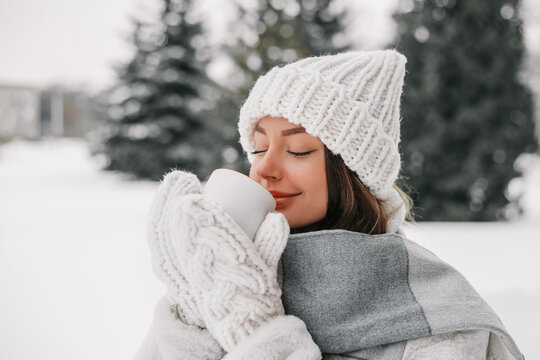 Ukrainian Woman Enjoying Hot Drink in Snowy Winter Landscape with Eyes Closed