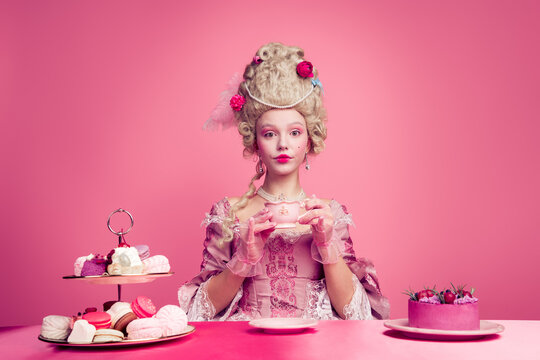 Photo of charming positive marie antoinette wear rich dress enjoying beverage desserts empty space isolated pink color background