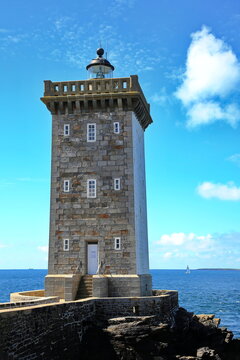 Kermorvan-Leuchtturm an der felsigen K&uuml;ste der Bretagne. Das historische Bauwerk steht auf einer Landzunge umgeben vom blauen Atlantischen Ozean unter strahlendem Himmel.