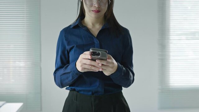 Business woman using a smartphone in a modern office, ideal for mobile app, online communication, messaging, digital technology and business workflow concepts