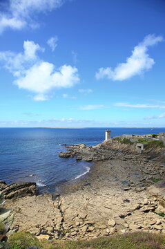 Kermorvan-Leuchtturm an der felsigen K&uuml;ste der Bretagne. Das historische Bauwerk steht auf einer Landzunge umgeben vom blauen Atlantischen Ozean unter strahlendem Himmel.