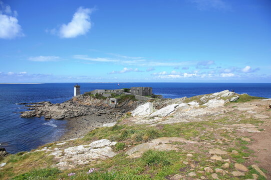 Kermorvan-Leuchtturm an der felsigen K&uuml;ste der Bretagne. Das historische Bauwerk steht auf einer Landzunge umgeben vom blauen Atlantischen Ozean unter strahlendem Himmel.
