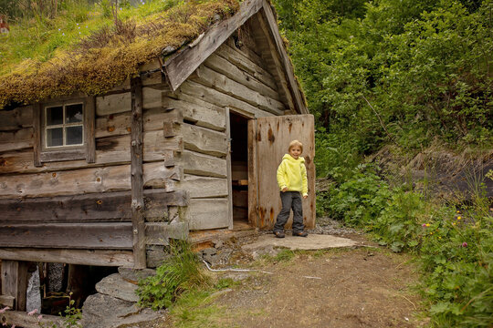 Amazing little wooden small house next to a waterfall on the dock of Hellesylt, child playing in the house