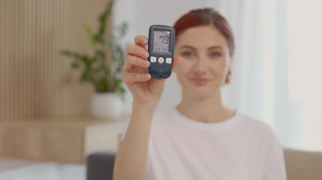 Woman demonstrates a glucometer reading of 79 mg dL at her home. She shares the importance of monitoring blood sugar levels for diabetes management.