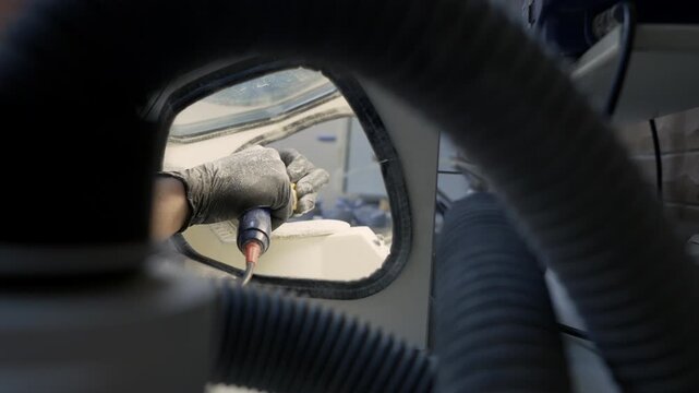 A lab specialist cleans multiple plaster jaw casts with an abrasive blaster, rotating each model to reach every surface