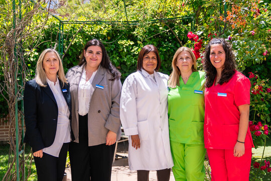 Diverse female healthcare team posing together outdoors, representing dedicated elderly care and medical support services at a facility