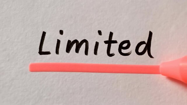 Red marker writing the word Limited on white paper