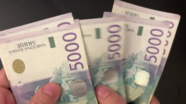 Counting Serbian dinar banknotes. Female hands counting 5000 RSD bills. Savings, investment and personal finance concept