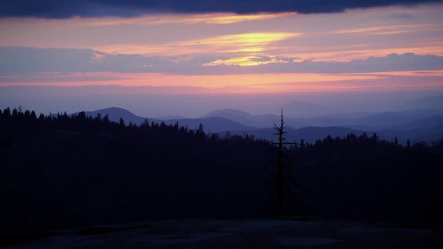 Vibrant sunset time lapse in Sequoia National Park, California as sun dips below forest and valley below.