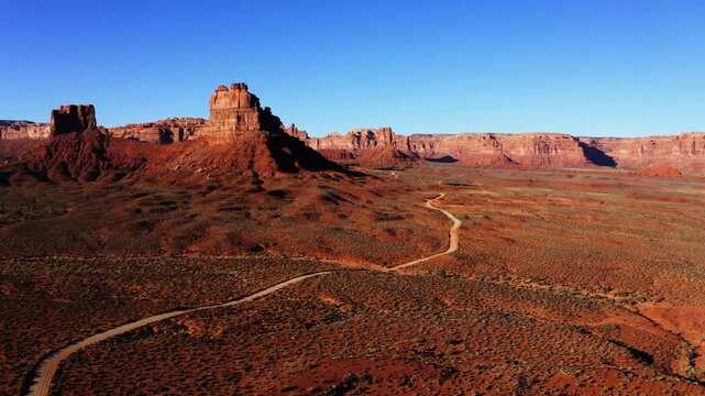 Wide aerial shot of dirt road approaching Valley of the Gods, Utah.