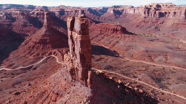 Wide shot of multiple sandstone buttes in Valley of the Gods, Utah from a drone perspective.