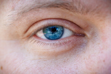 Obraz premium Extreme macro close-up of a beautiful blue human eye: detailed texture of the iris, pupil, and eyelashes, vision and ophthalmology concept