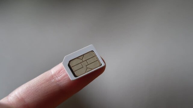 Close up of a sim card for a smart phone on finger