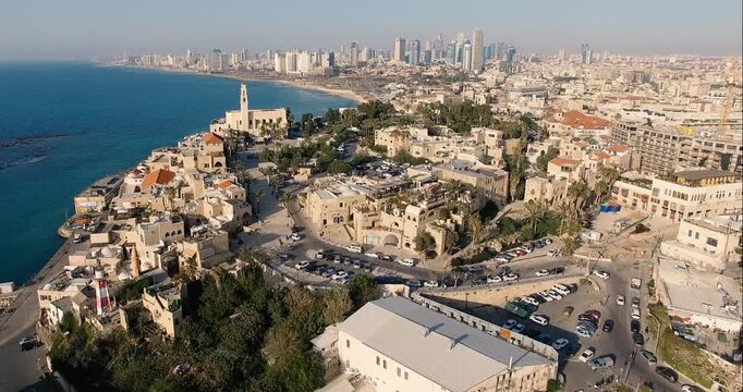 Aerial drone shot of Old Jaffa and the Tel Aviv skyline in Israel. Scenic Mediterranean coastline, historic buildings, city skyline, urban landscape and coastal views captured in daylight.