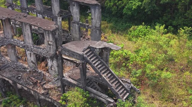 Cinematic aerial shot of the bombedout remains of military barracks on Corregidor Island, Philippines. A haunting reminder of WWII history reclaimed by nature.