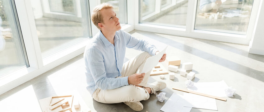 blank letter mockup Scandinavian man sunroom documents reading message minimalist Closer composition emphasizes the blank surface and private emotional response young man sits among scattered