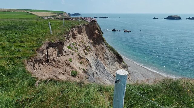 Coastal erosion land slip of cliffs into the sea at Waterford Ireland result of winter storms