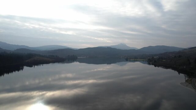 Reflections on a loch on a cloudy day, with Ben Lomond in the background