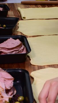 Close up of men working in parallel making pan de jamon on wood tables