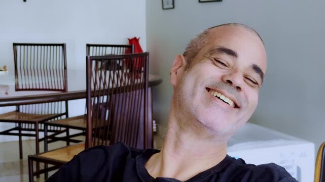 Close-up of a mature man giving a sarcastic laugh and mocking chuckle with a cynical expression, symbolizing disbelief, fake happiness, irony, or smug humor