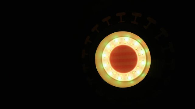A circular LED light fixture emits a bright magenta and white glow. The intense illumination stands out in stark contrast against the completely dark background. Individual diodes shine clearly.