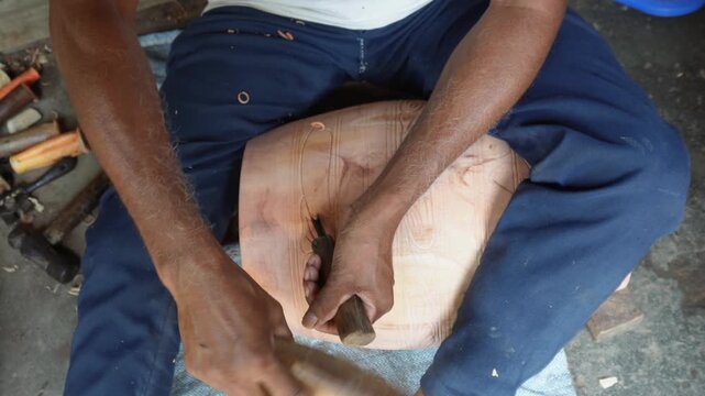 Artisan carving detailed wooden mask by hand