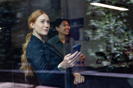 Businesswoman making financial investments using a smartphone