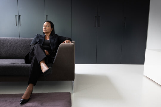 Confident Woman Sitting on Couch in Office