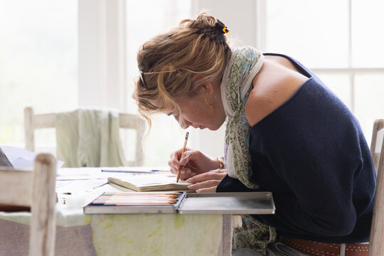 20 year old woman artist working on a drawing in her studio