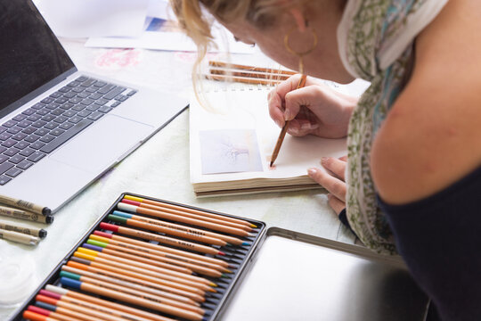 20 year old woman artist working on a drawing in her studio