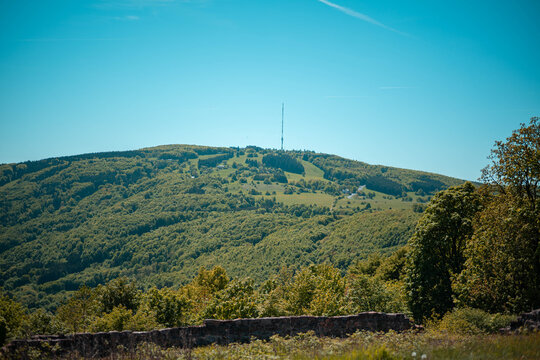 Weites Panorama vom Kreuzberg &uuml;ber bl&uuml;hende Bergwiesen auf Bischofsheim und Haselbach in der Rh&ouml;n