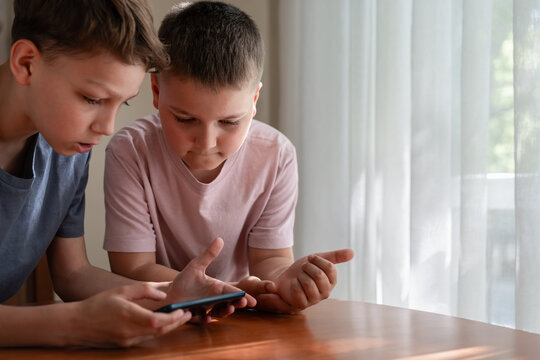 Generation Alpha boys interacting with educational content on smartphone. Digital literacy, collaborative learning, technology use and connected childhood concept.