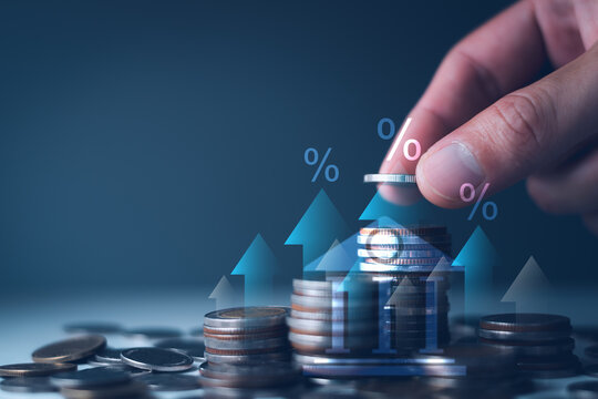 Hand adding a coin to stacks with percentage icons. concept federal reserve interest rate hikes, inflation control, central bank monetary policy, financial global economy, and investment impact.