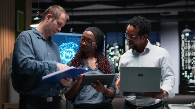 Portrait of engineering team developing AI algorithms in high rise office. Teamworking colleagues debug 3D neural network brain models shown on screen.