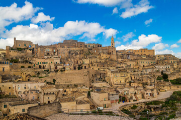 Obraz premium Panoramic view to the Sassi di Matera, an ancient cave-dwelling complex in the city of Matera, Basilicata, Southern Italy with the historic Cathedral on top of the hill. UNESCO World Heritage Site