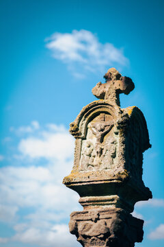 Historischer Sandstein-Bildstock mit Kreuzigungs-Relief vor blauem Himmel in Bad Staffelstein
