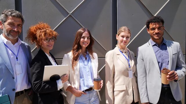 Diverse business team smiling and posing outdoors