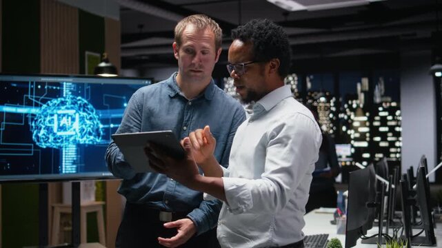 Engineering team using tablet in office, working with AI programming languages with teamwork and productivity context for AI development workflow.