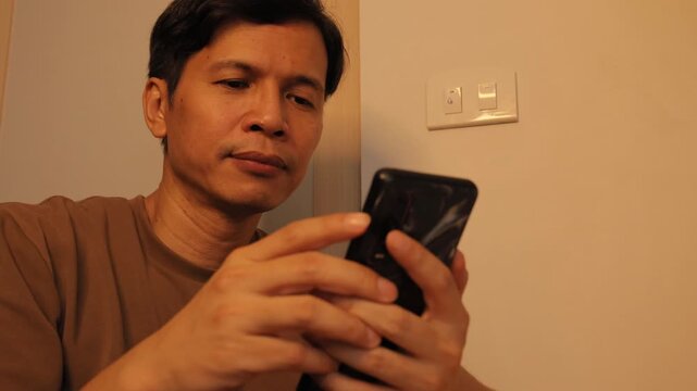 Smiling Man Using Smartphone and Reading Good News