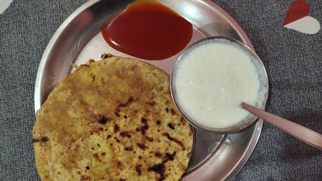Traditional Indian Meal with Aloo Paratha, Curd, and Sauce