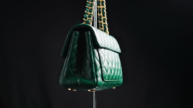 Green quilted leather handbag with gold chain strap showcased on a dark background. Elegant and luxurious mood. Perfect for fashion retail and advertising.
