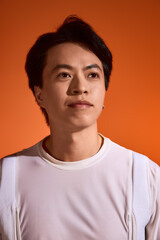 Fototapeta premium Stylish young man displays unique fashion sense against vibrant studio backdrop