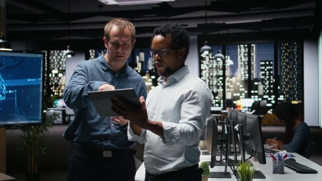 Teamworking tech startup coworkers using tablet, brainstorming ways to optimize performance in office with debugging and troubleshooting context.