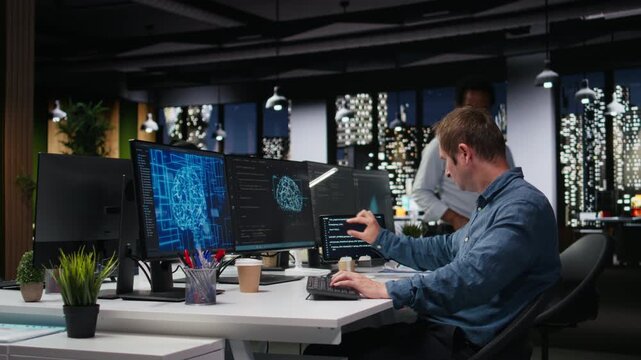 Tech startup IT expert developing artificial intelligence algorithms in high rise office late at night. System administrator debugging neural network brain models on screens for coding workflows.