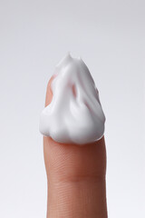 Fototapeta premium close up of a finger with cream smear on it, cream on a finger