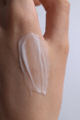 Fototapeta premium female hand with a cream swatch on it, cream on a hand