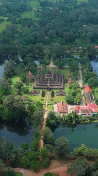 Vertical drone orbits right over Bakong Temple, showing the moat, sanctuary, jungle, and grounds in Siem Reap